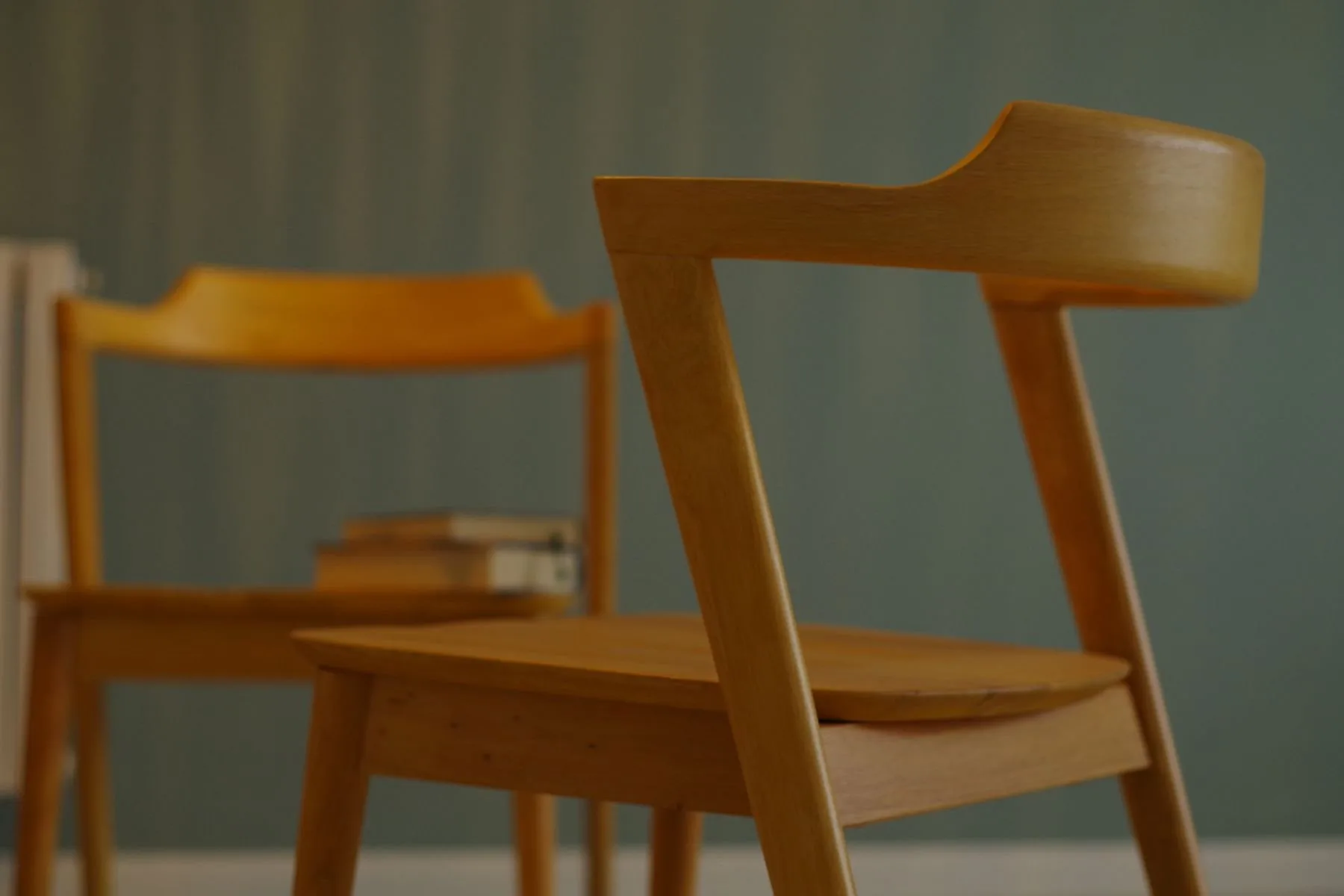 Detalle de sillas de madera con respaldo curvo y uniones visibles.