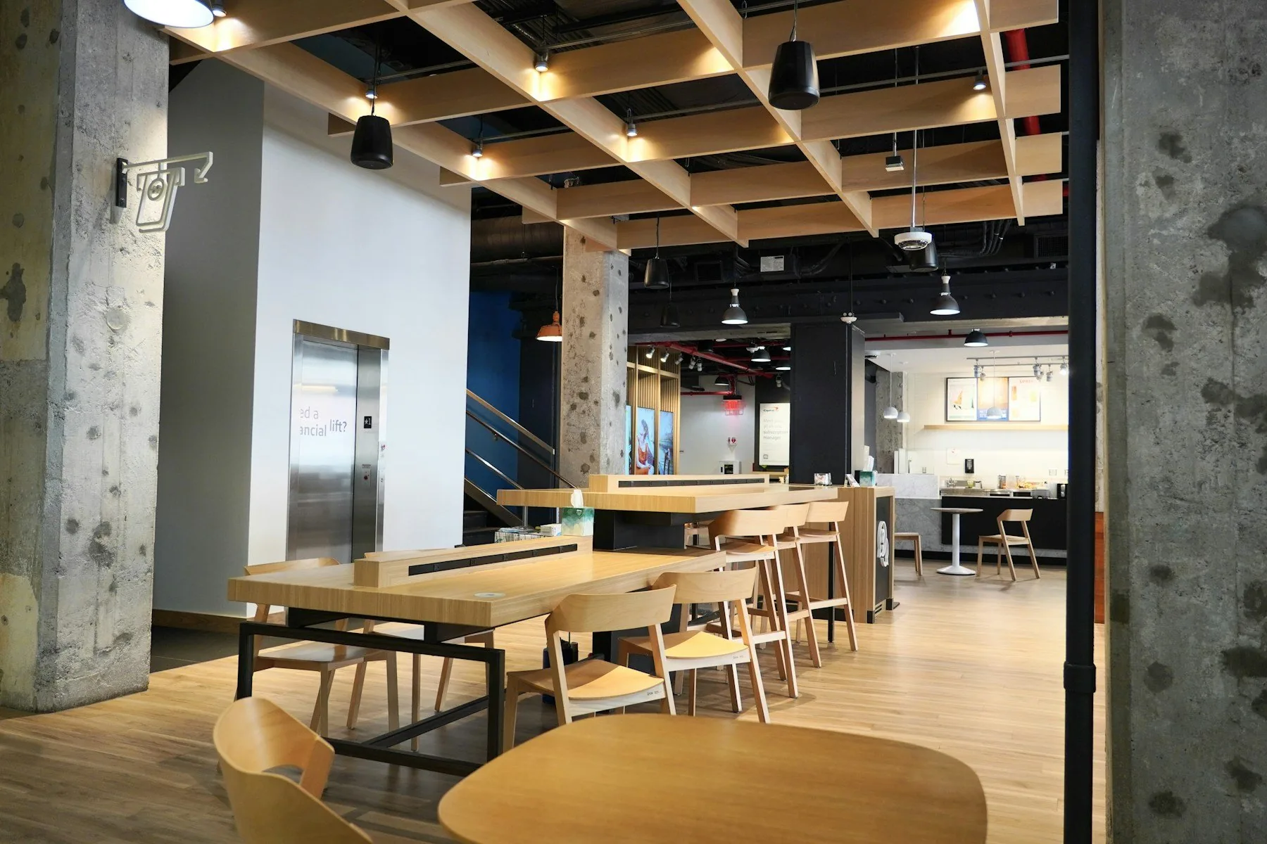 Café contemporáneo con mesas y techo de madera.