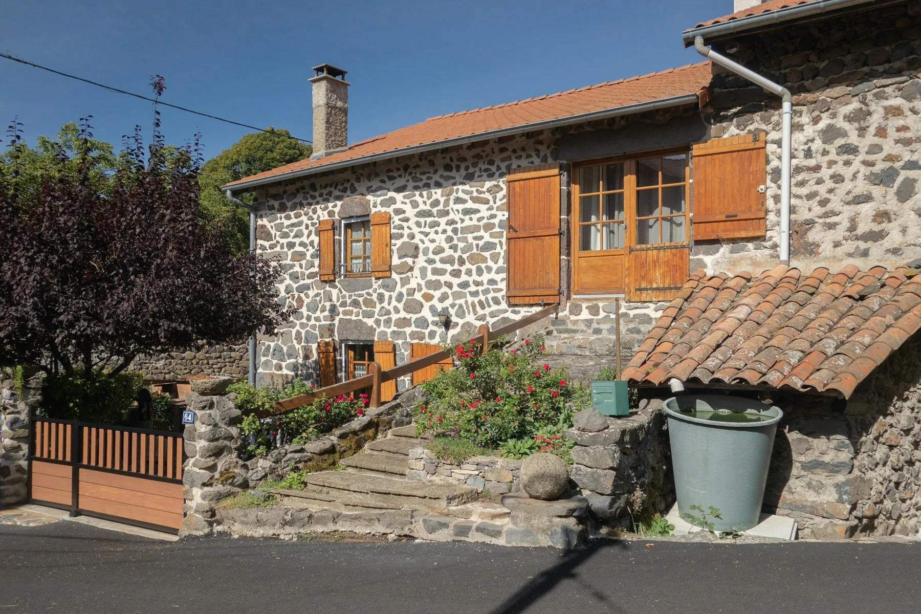 Fachada de una casa tradicional de piedra con contraventanas de madera.